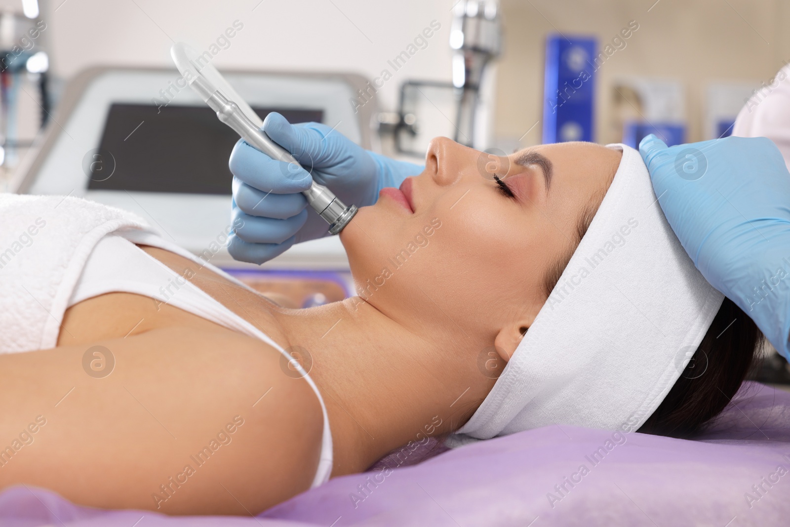 Photo of Young woman undergoing cosmetic procedure in beauty salon. Microcurrent therapy