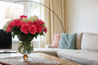 Photo of Vase with beautiful bouquet of roses on wooden table at home, space for text