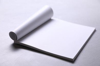 Blank paper sheets on grey textured table, closeup. Mockup for design