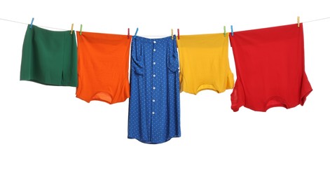 Different clothes drying on laundry line against white background