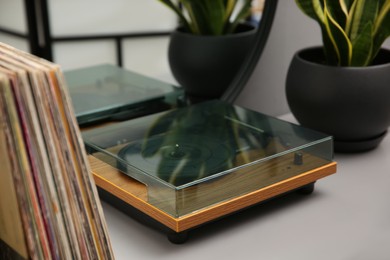 Photo of Stylish turntable and vinyl records on table indoors