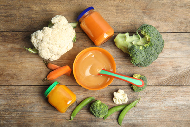 Flat lay composition with healthy baby food and ingredients on wooden table