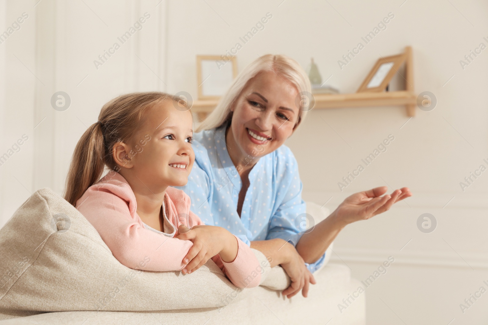 Photo of Happy grandmother spending time with her granddaughter at home