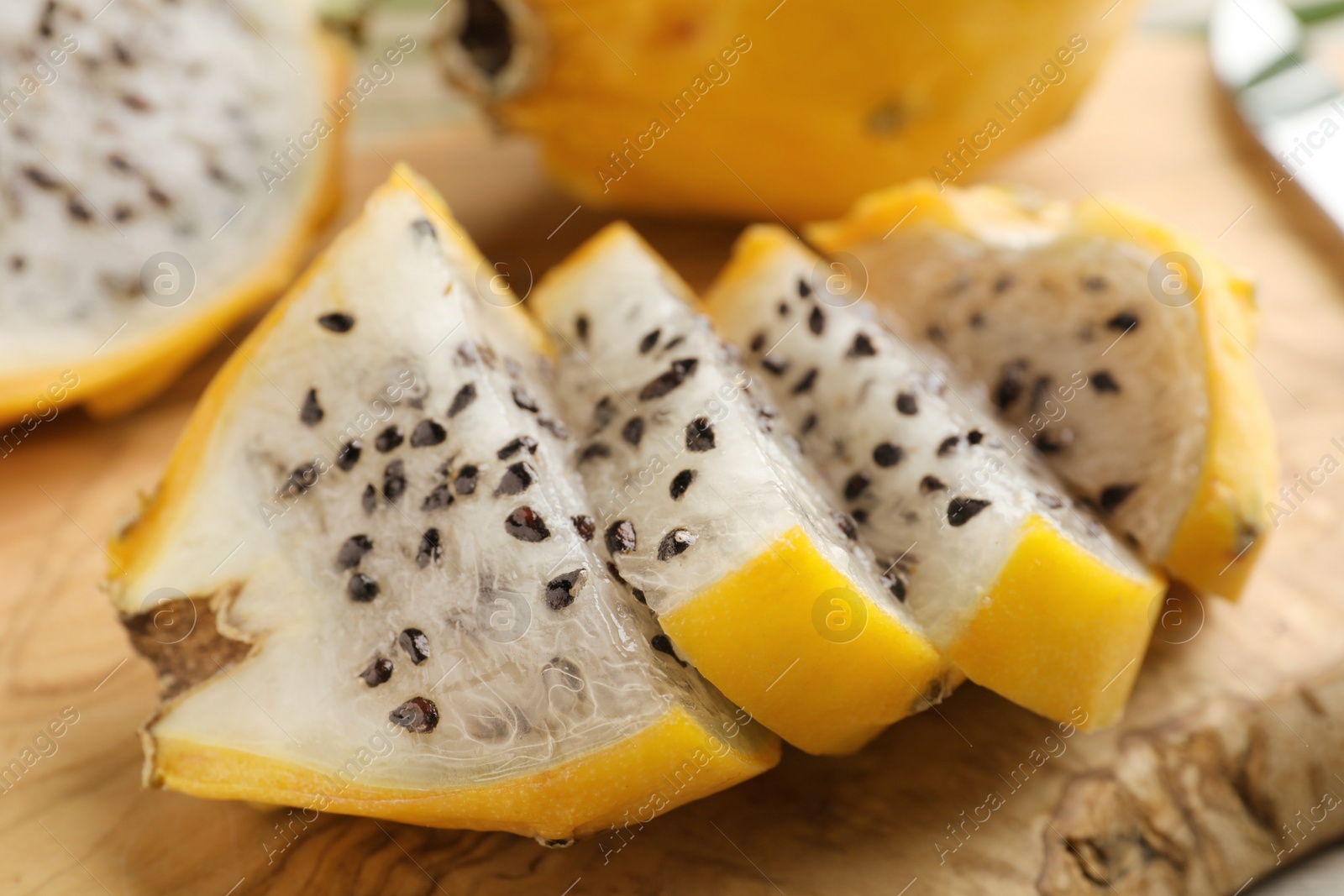 Photo of Delicious cut dragon fruit (pitahaya) on wooden board, closeup