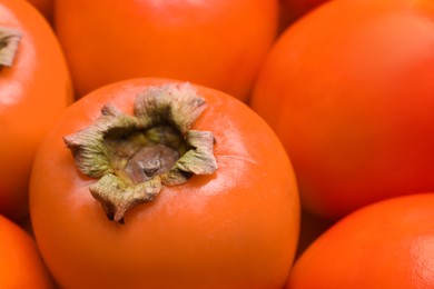 Photo of Delicious ripe juicy persimmons as background, closeup