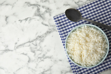 Photo of Bowl with tasty cooked rice on marble table, flat lay. Space for text