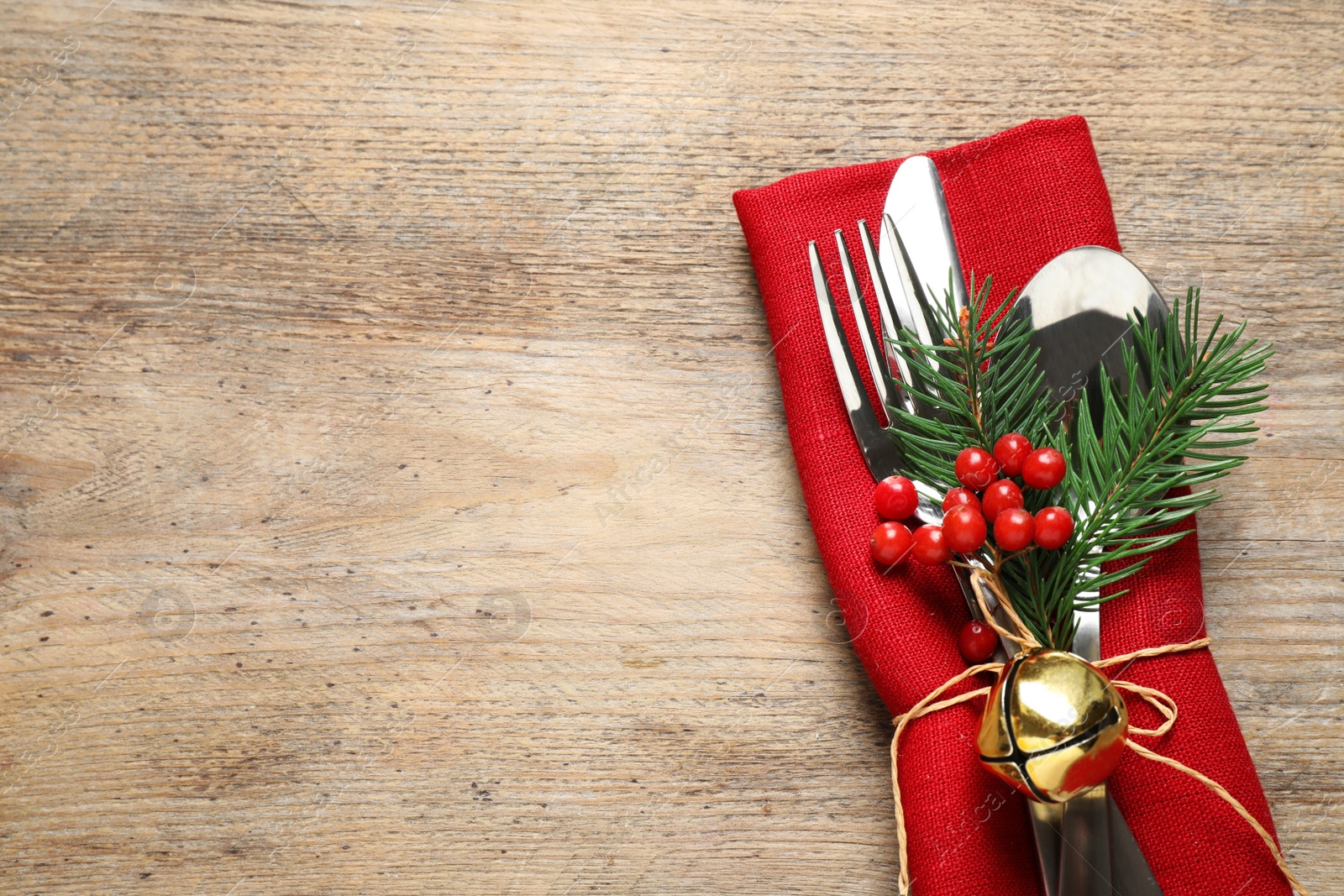 Photo of Cutlery set on wooden table, top view with space for text. Christmas celebration