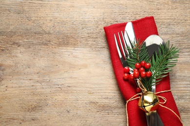 Photo of Cutlery set on wooden table, top view with space for text. Christmas celebration