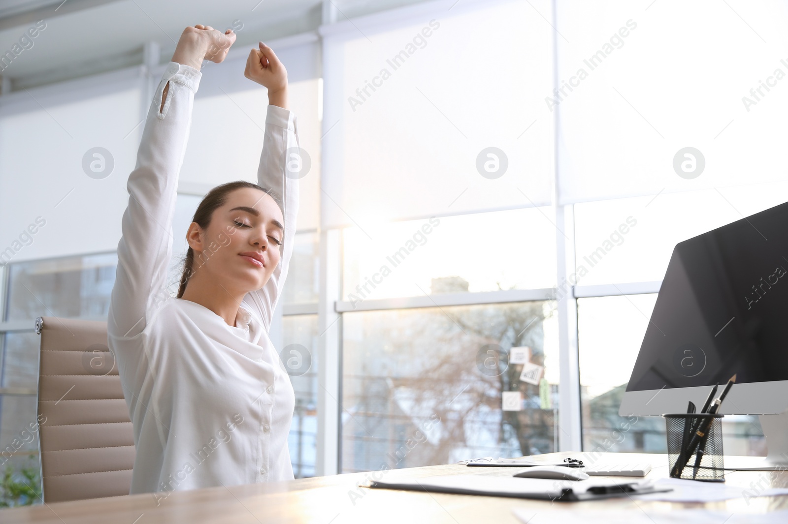 Photo of Young woman relaxing in office chair at workplace