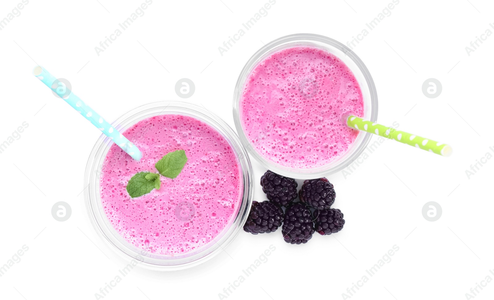 Photo of Glasses of blackberry smoothie and berries on white background, top view
