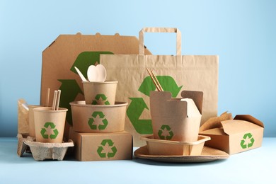Image of Set of eco friendly food packaging with recycling symbols on light blue background