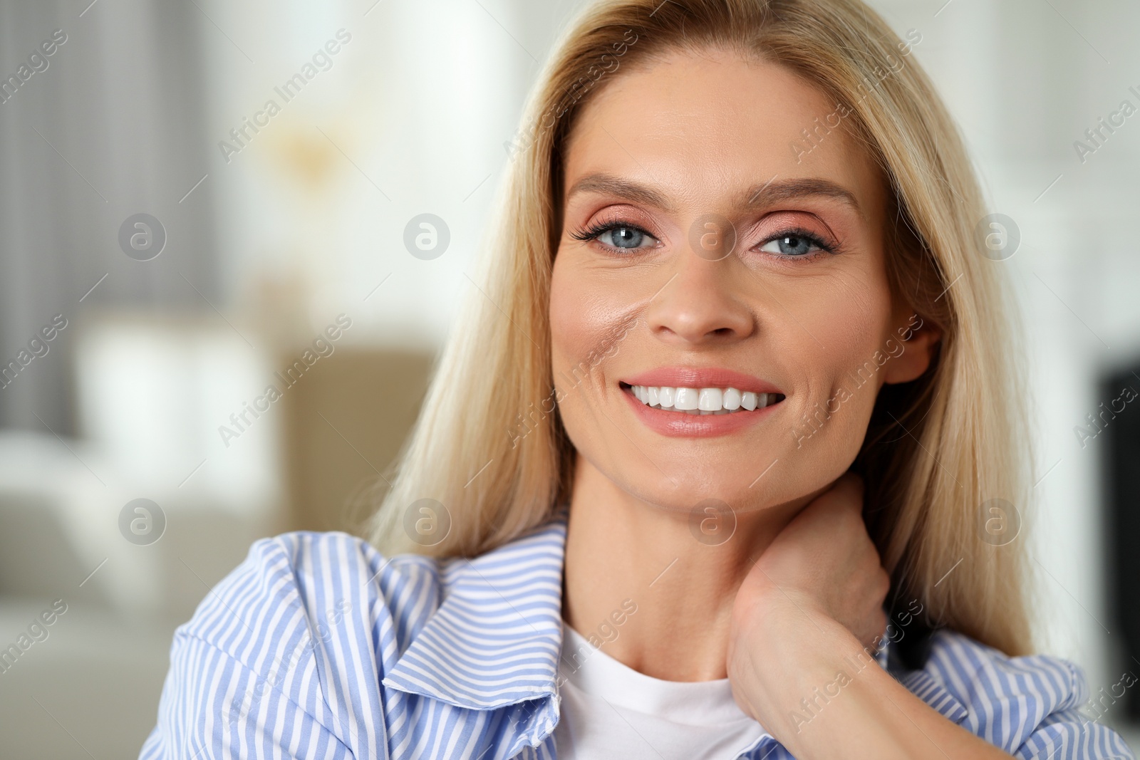 Photo of Portrait of smiling middle aged woman with blonde hair indoors