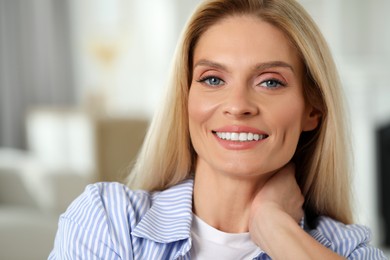 Portrait of smiling middle aged woman with blonde hair indoors
