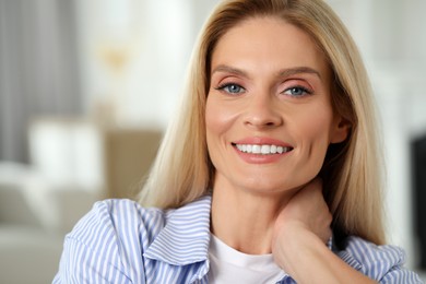 Photo of Portrait of smiling middle aged woman with blonde hair indoors