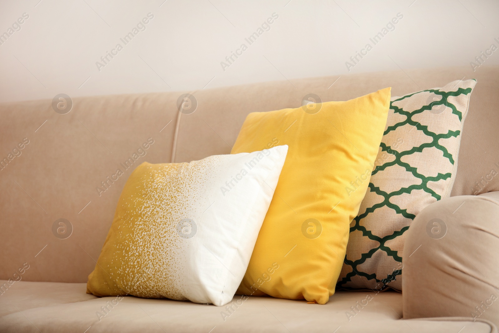 Photo of Different soft pillows on sofa in room