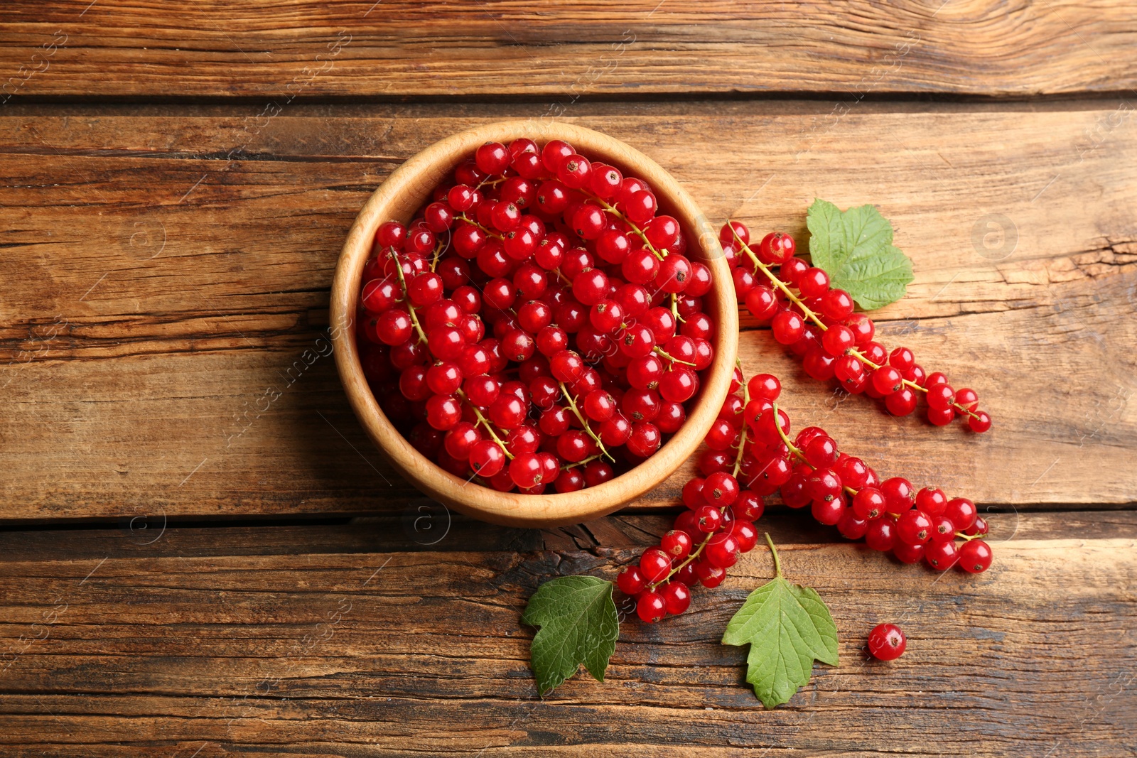Photo of Delicious ripe red currants on wooden table, flat lay