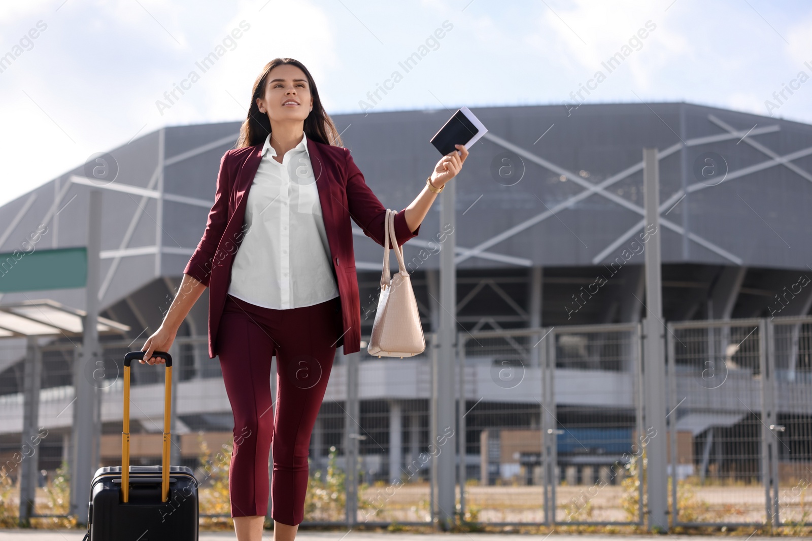 Photo of Being late. Businesswoman with black suitcase and passport running outdoors, space for text