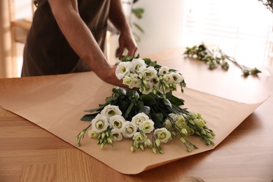 Photo of Florist making beautiful bouquet in workshop, closeup
