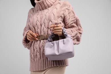 Photo of Fashionable woman with stylish bag on light background, closeup