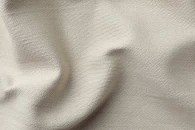 Texture of beige crumpled fabric as background, top view