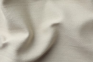 Photo of Texture of beige crumpled fabric as background, top view