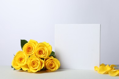 Beautiful presentation for product. Square figure and yellow roses on white table, space for text