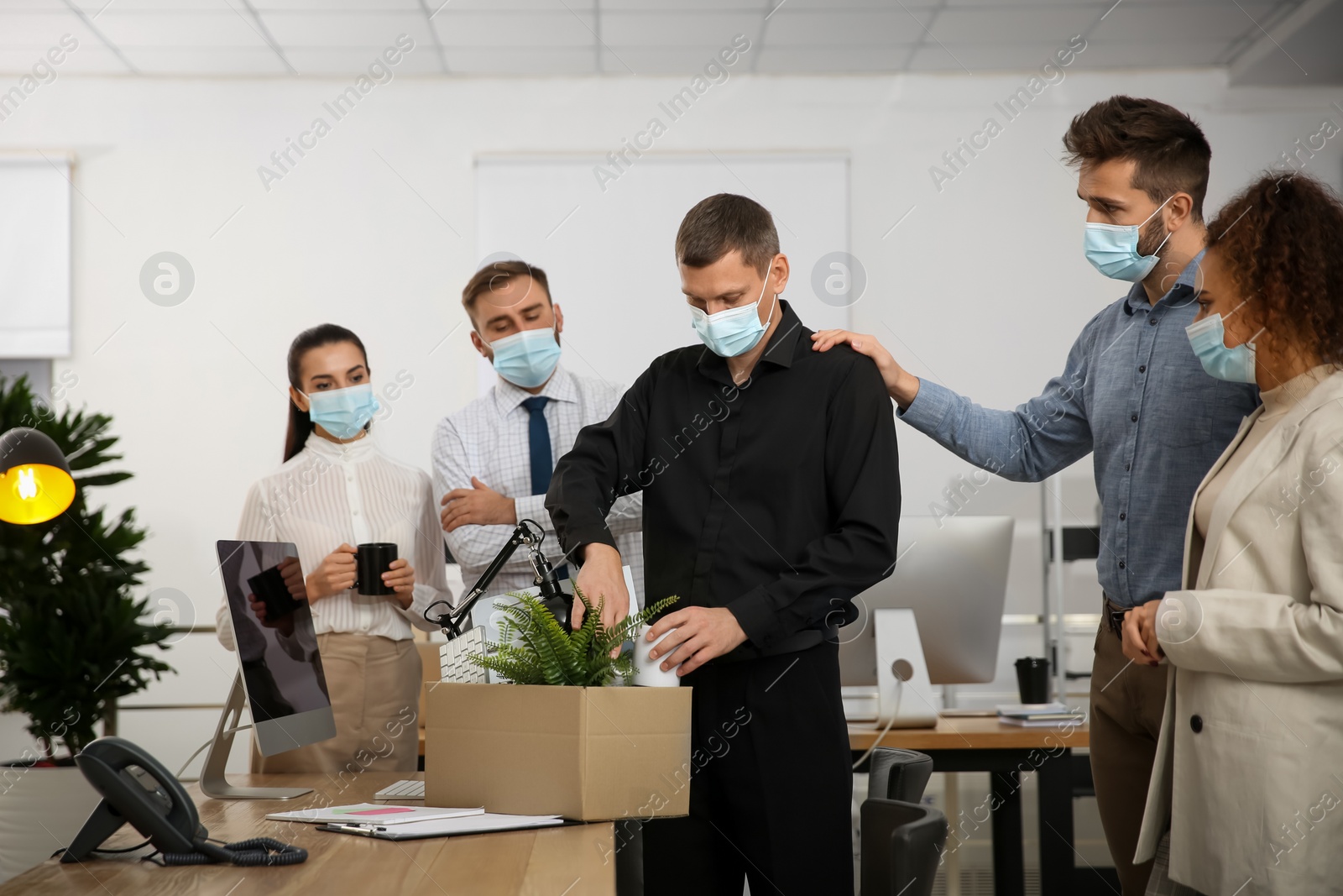 Photo of Coworkers saying goodbye to dismissed man in office