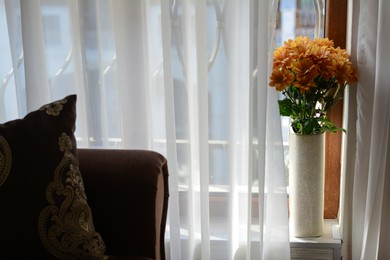 Photo of Bouquet of beautiful chrysanthemum flowers in vase near window indoors. Space for text