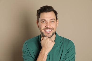 Smiling man with perfect teeth on color background