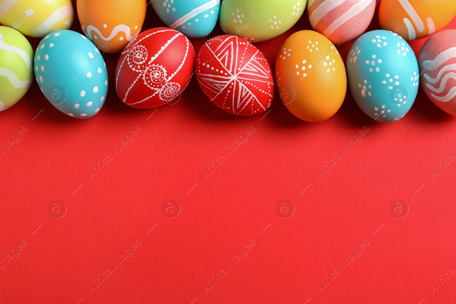 Photo of Flat lay composition of painted Easter eggs on color background, space for text