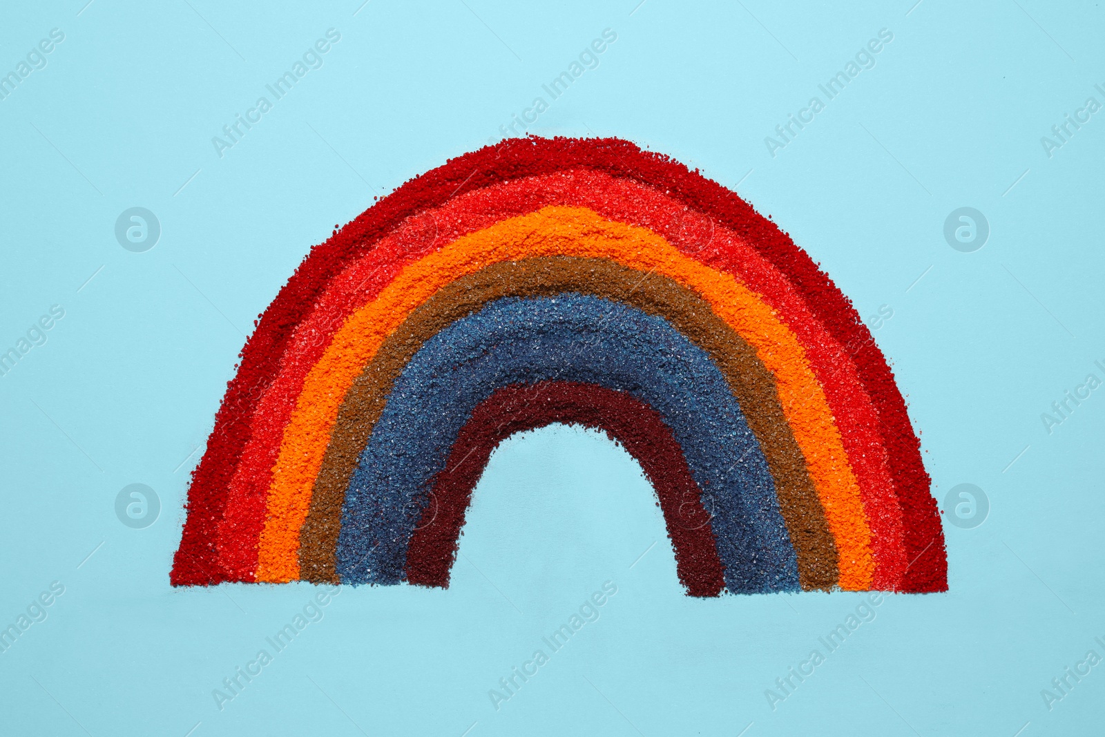 Photo of Rainbow made of different food coloring on light blue background, top view