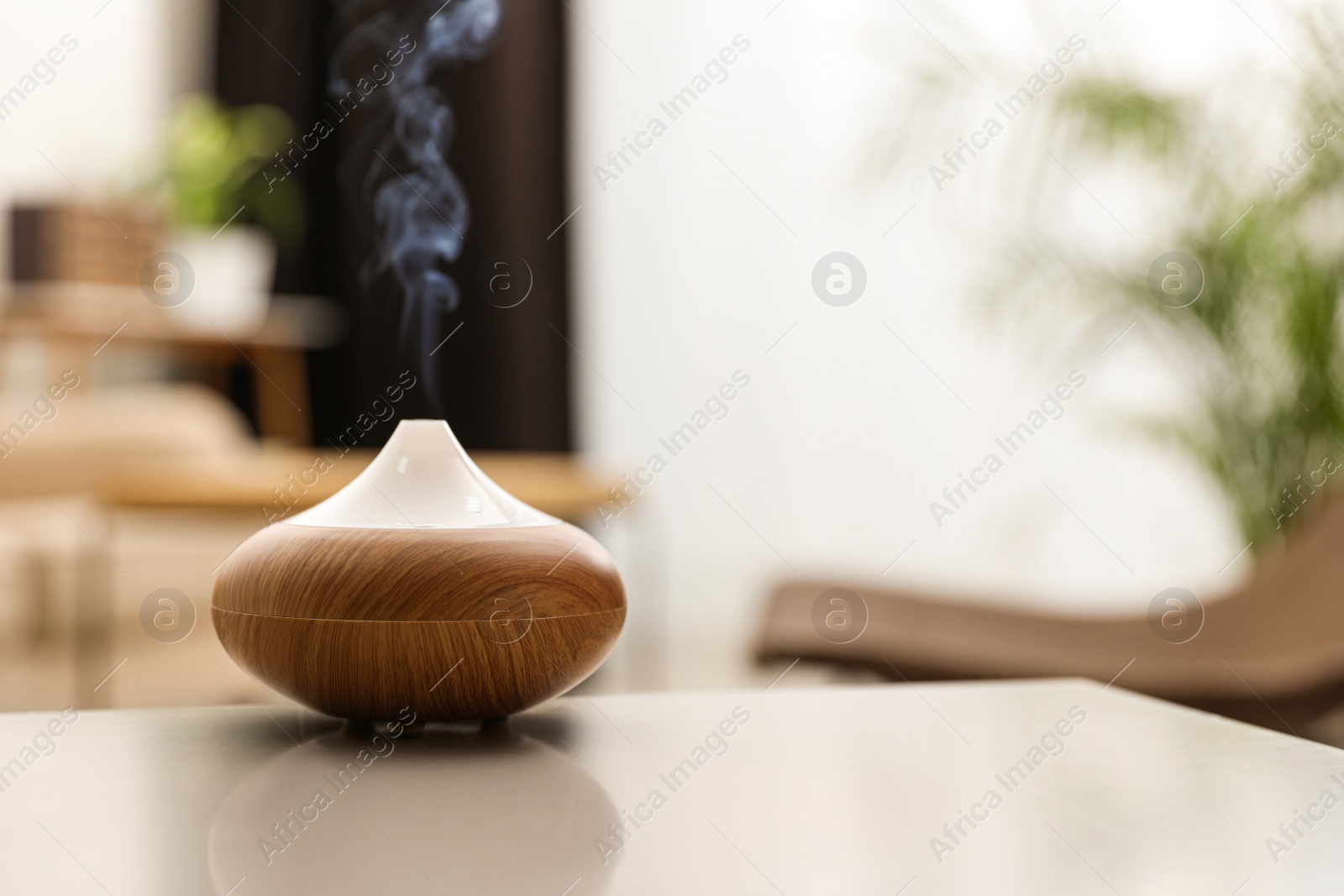 Photo of Aroma oil diffuser on light table at home, space for text. Air freshener