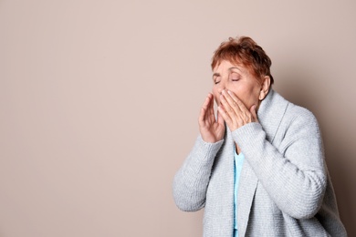 Photo of Elderly woman coughing against color background. Space for text