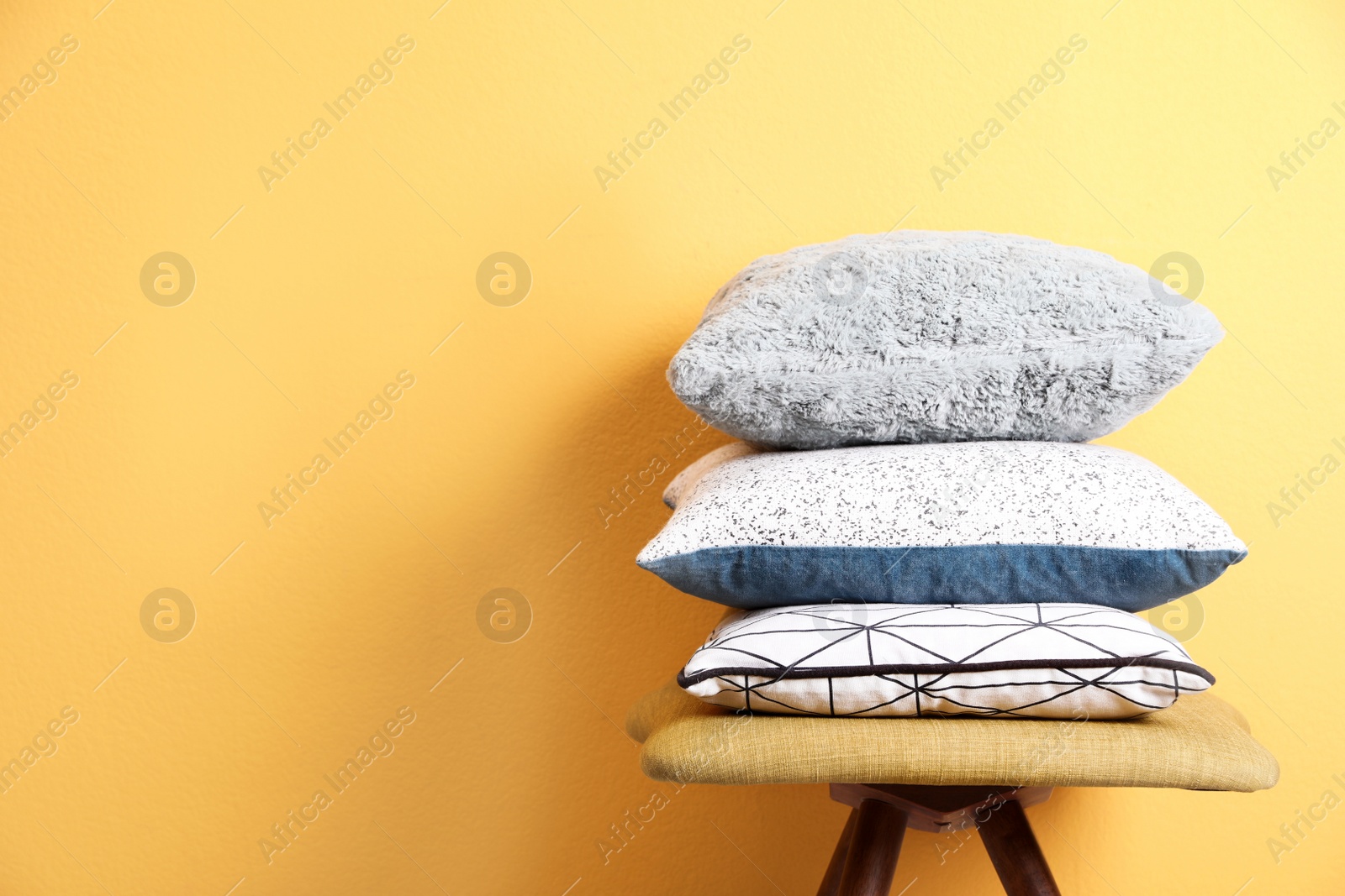 Photo of Chair with many different pillows and space for text on color background