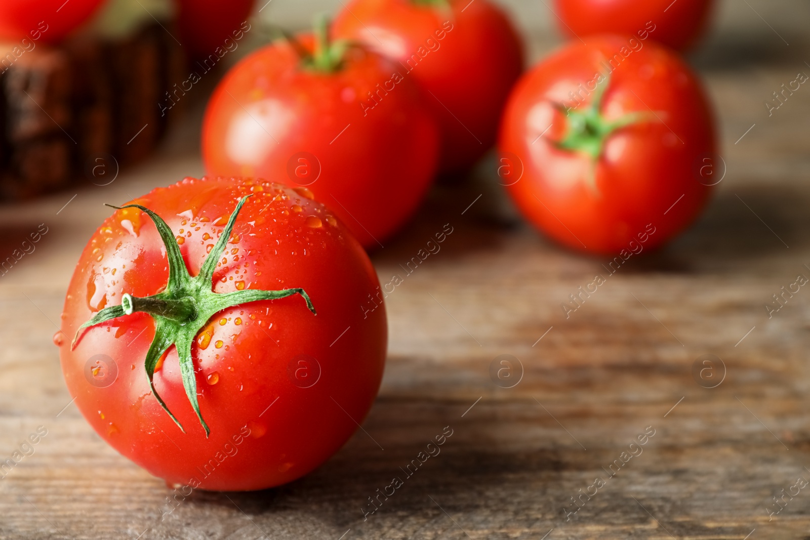 Photo of Fresh ripe tomatoes on wooden table, closeup