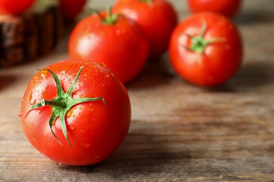 Fresh ripe tomatoes on wooden table, closeup