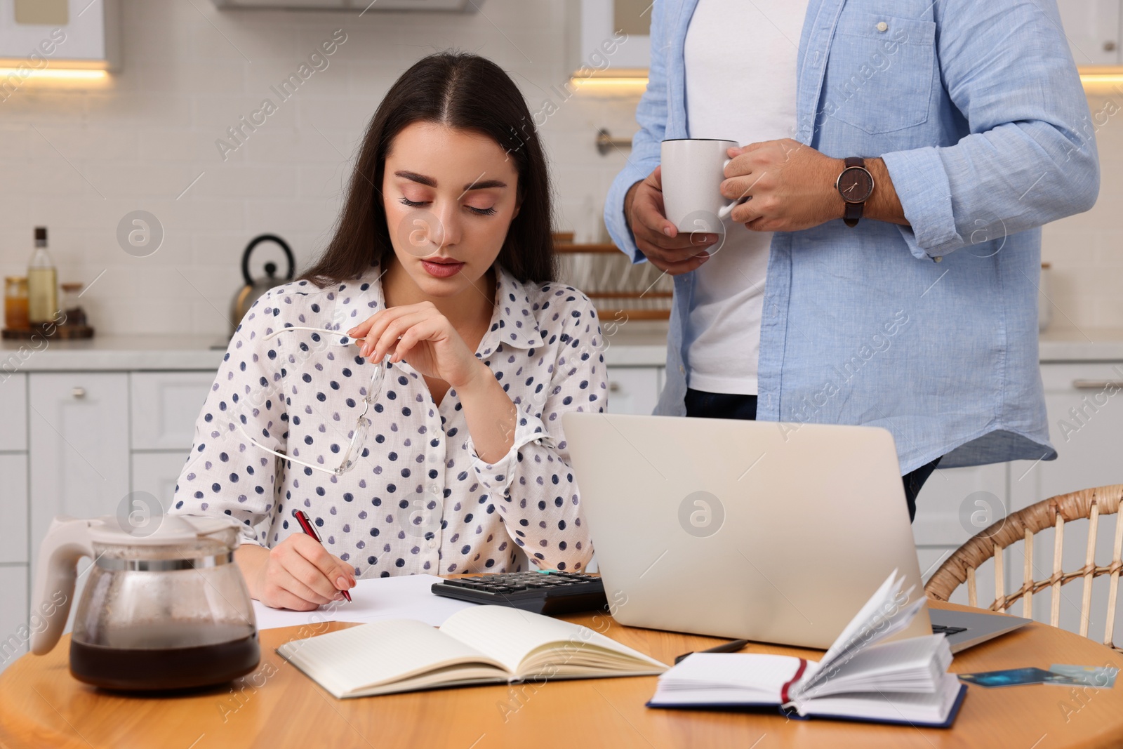 Photo of Young couple discussing family budget in kitchen