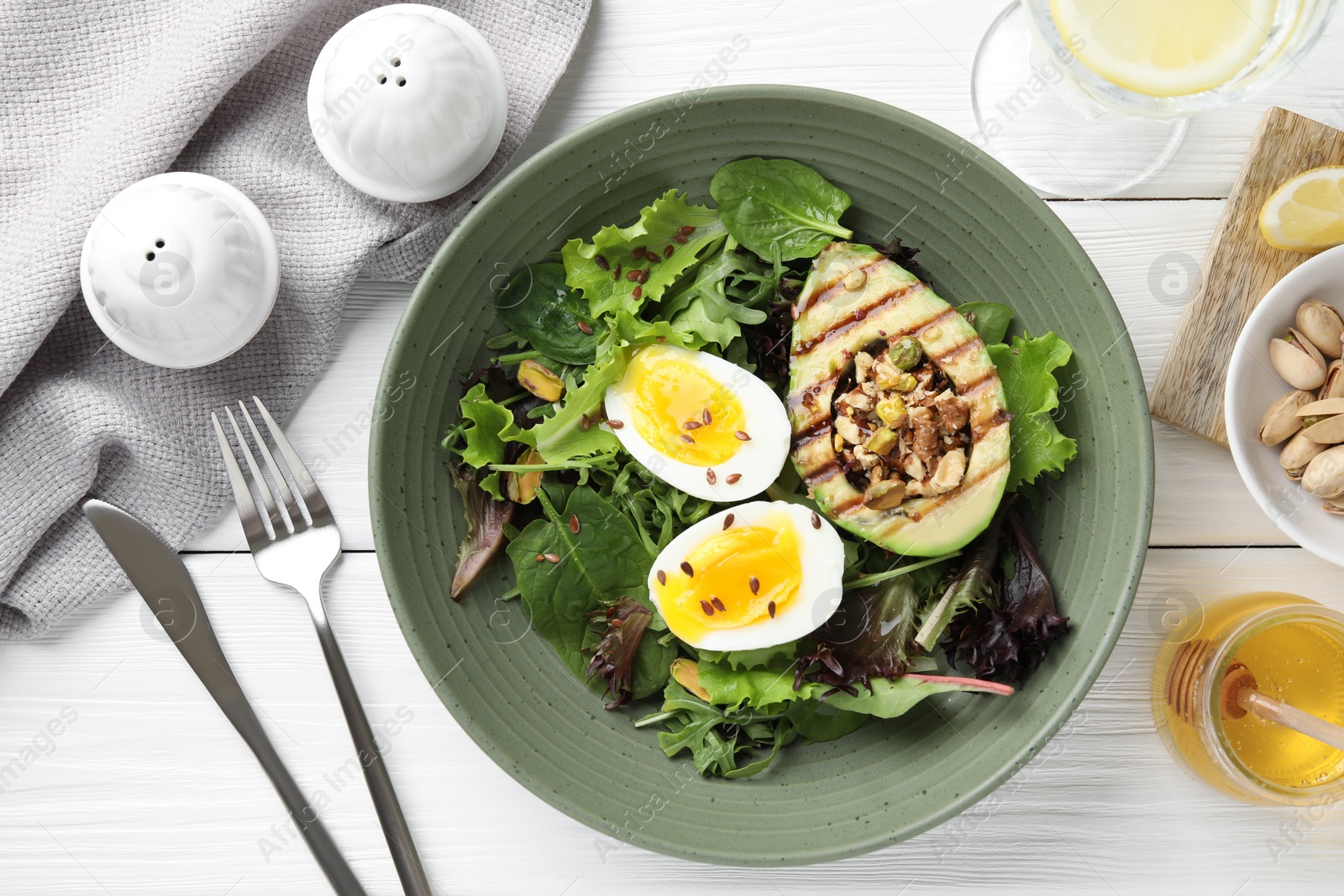 Photo of Healthy dish high in vegetable fats served on white wooden table, flat lay