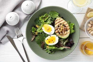 Healthy dish high in vegetable fats served on white wooden table, flat lay