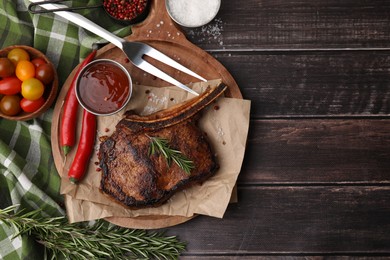 Tasty grilled meat, rosemary, marinade and chili on wooden table, flat lay. Space for text