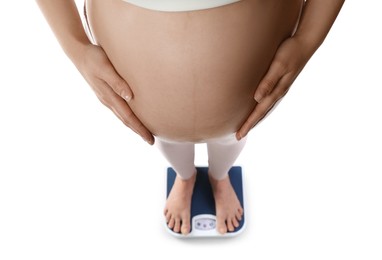 Photo of Pregnant woman standing on scales against white background, closeup