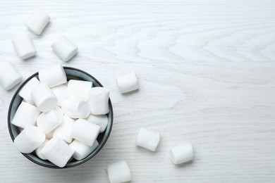 Delicious puffy marshmallows on white wooden table. Space for text