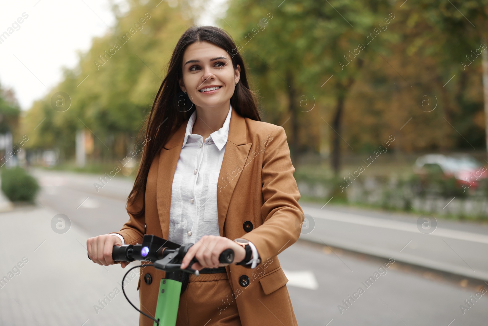 Photo of Businesswoman with modern electric kick scooter on city street