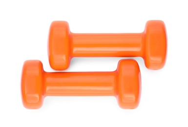 Orange dumbbells isolated on white, top view. Sports equipment