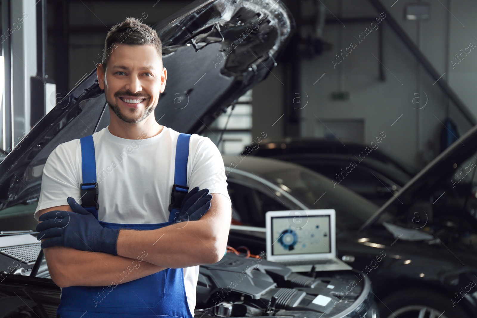 Photo of Mechanic near automobile in service center, space for text. Car diagnostic