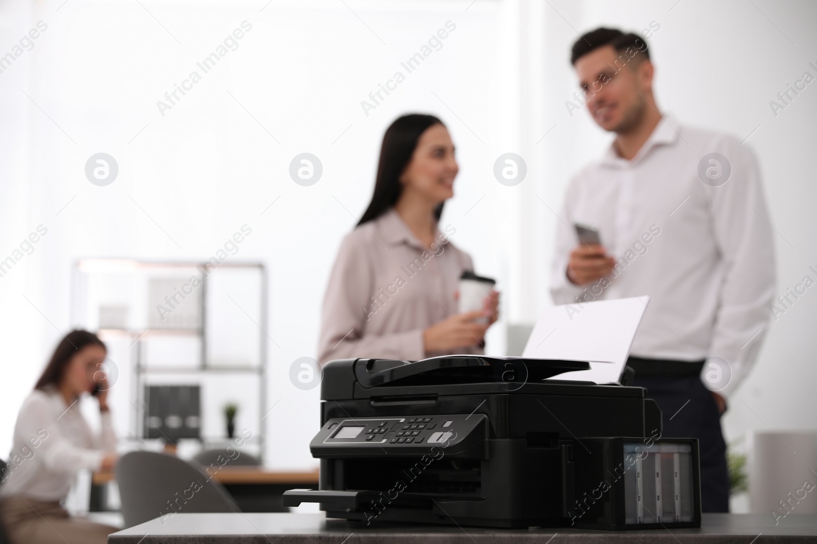 Photo of New modern printer on table in office. Space for text