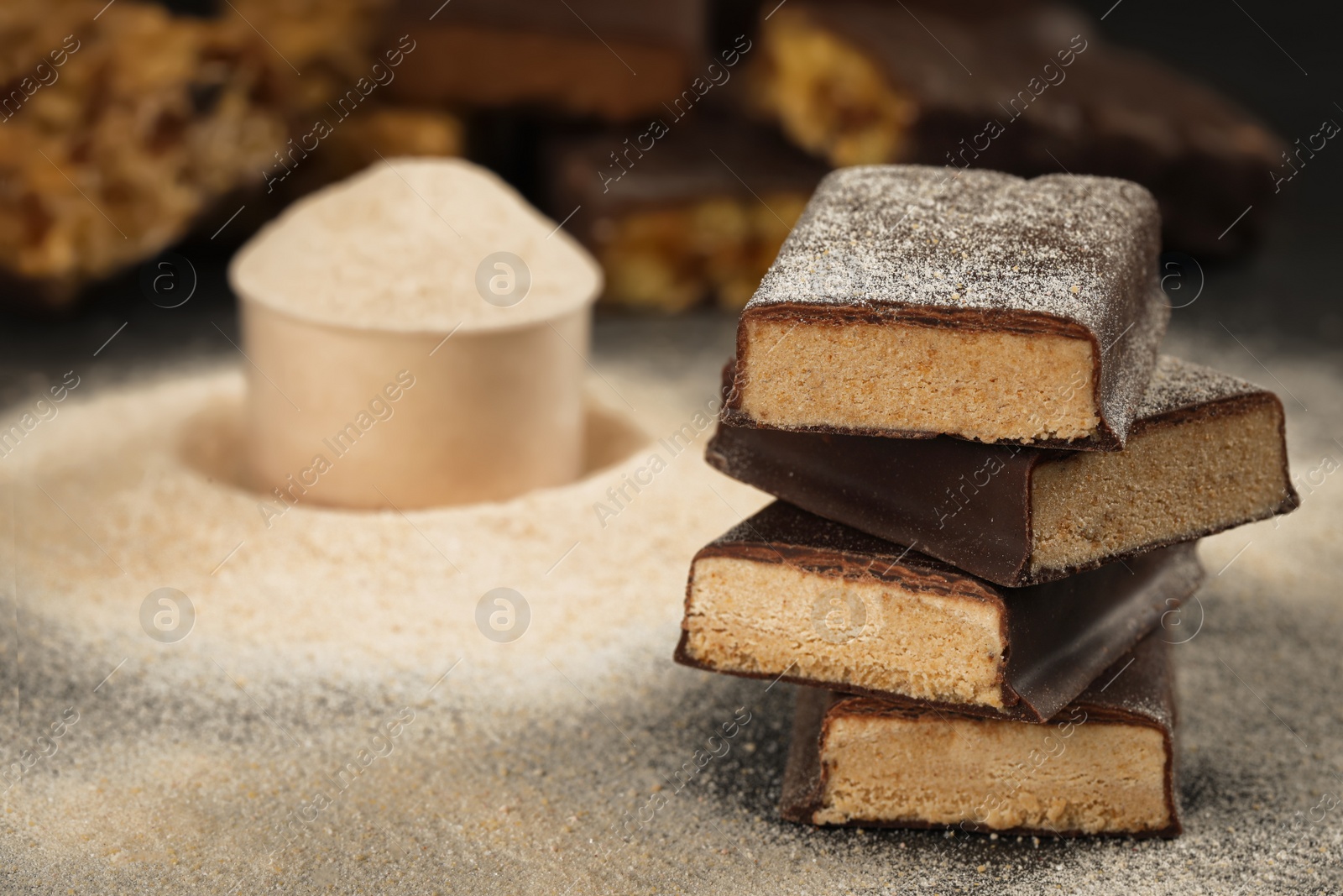 Photo of Tasty energy bars and protein powder on table, closeup. Space for text