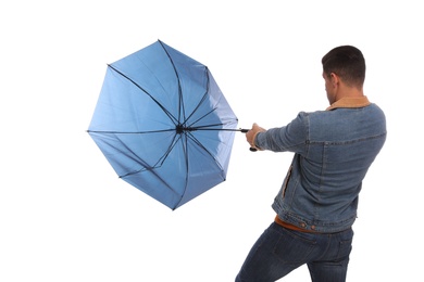 Man with umbrella caught in gust of wind on white background