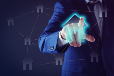 Image of Mortgage rate. Man touching illustration of house on virtual screen against dark background, closeup
