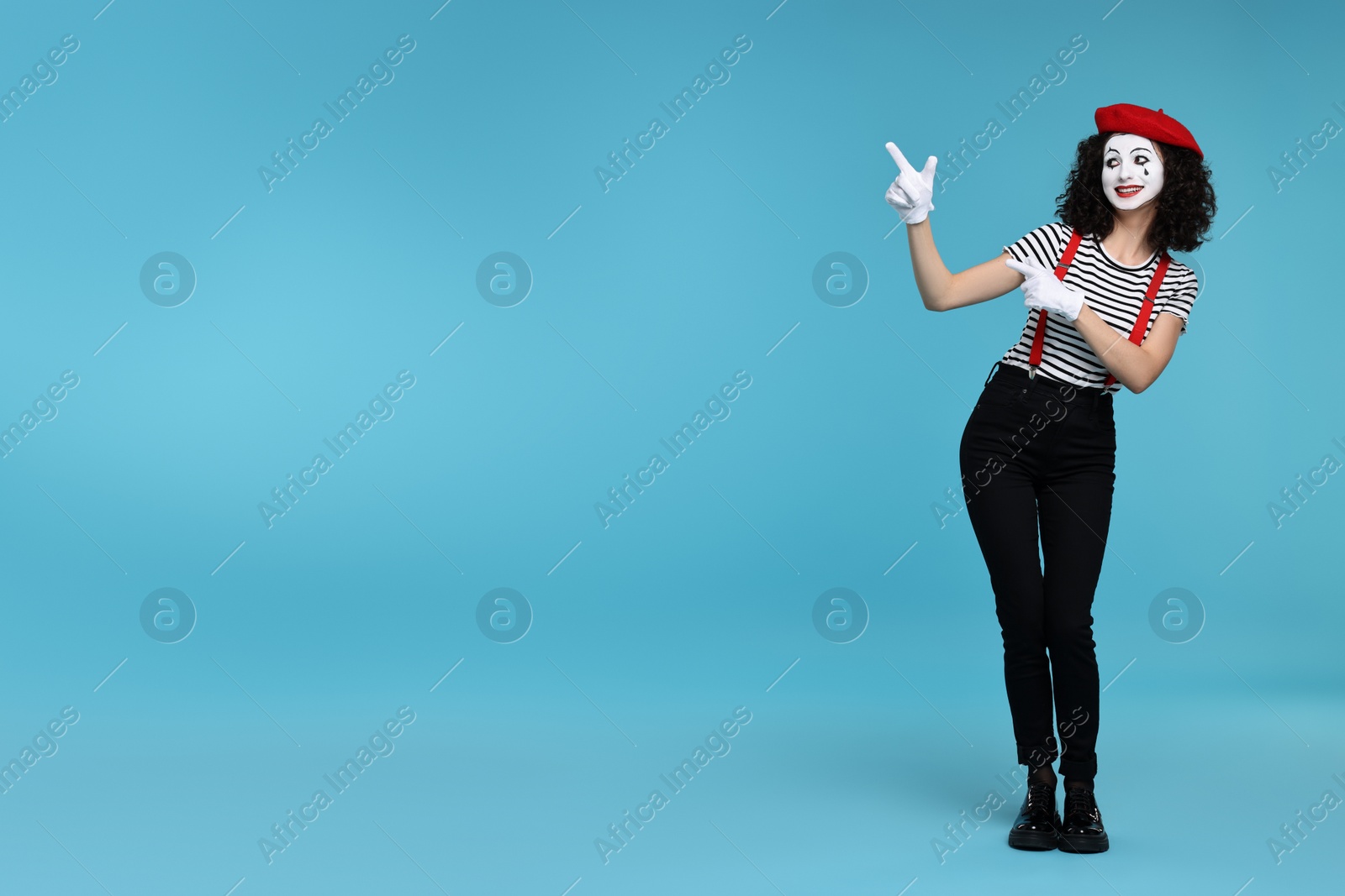 Photo of Funny mime with beret posing on light blue background, space for text